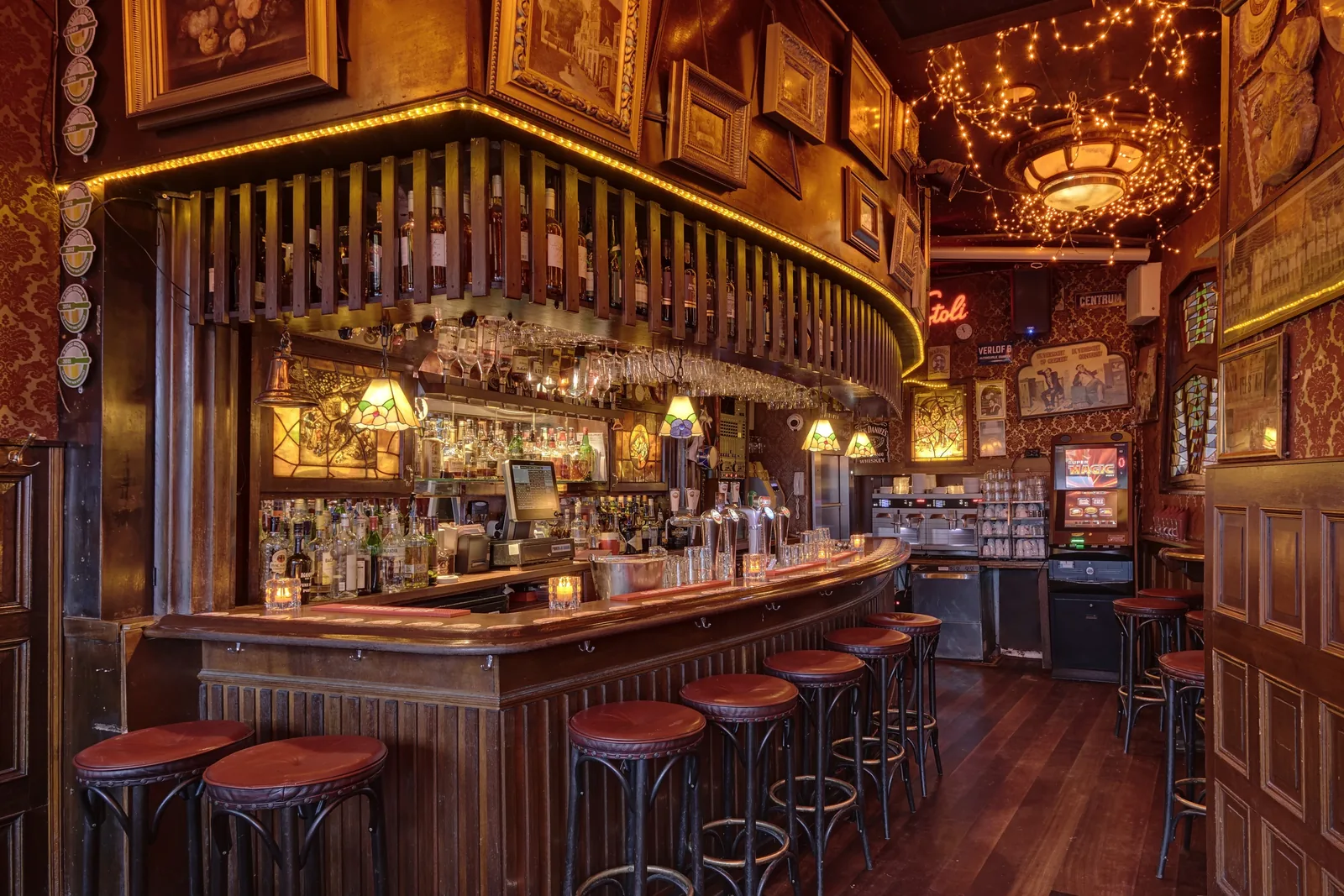The round brown bar with stools and glasses on the rack