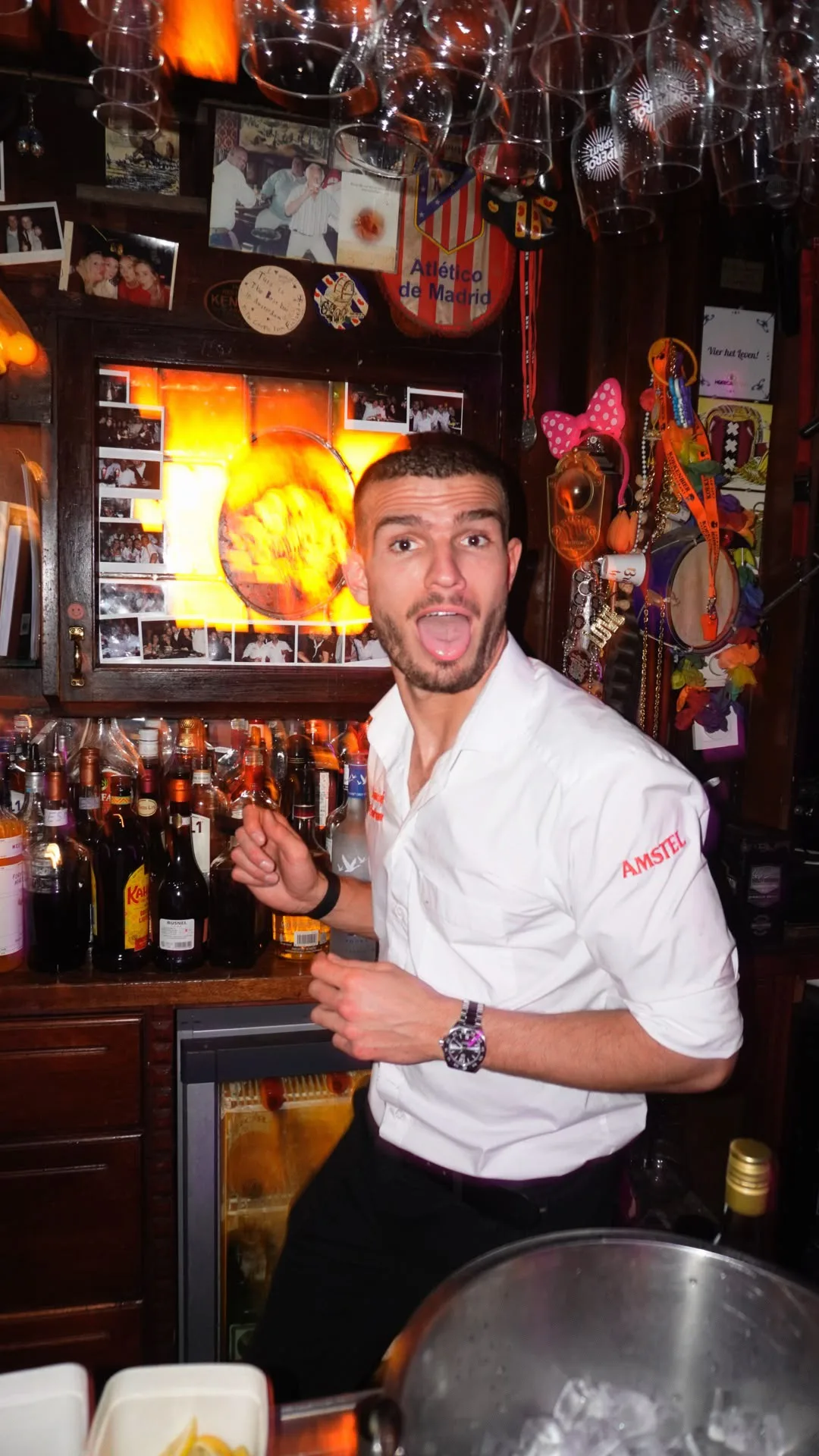 The barman with a broad smile behind the bar